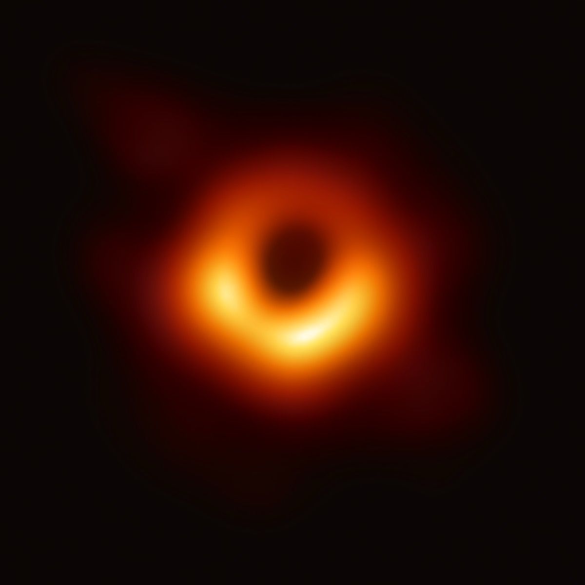 En suddig orange ljusring mot svart bakgrund, skuggan av det supermassiva svarta hålet i galaxen Messier 87.